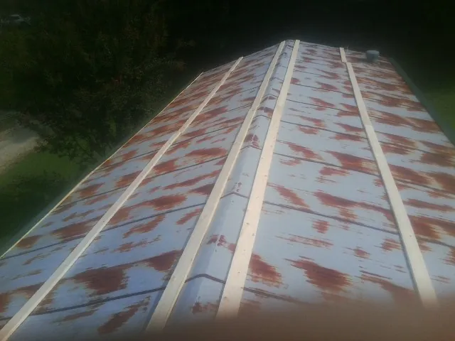 Rusted metal roof panels with new wood purlins before replacement — Storm Damage Roof Repair in Sun Valley by Roofing Brothers