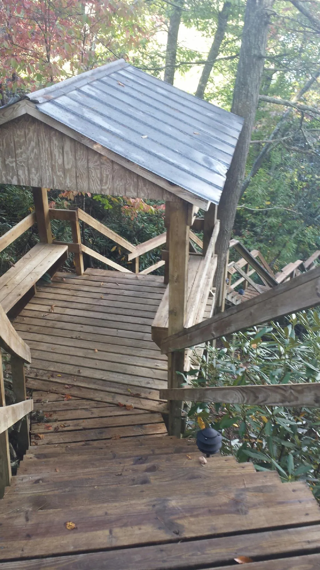 Metal roofed shelter over wooden steps on a wooded walkway — Skylight Repair & Installation work by our crew in Sun Valley